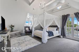 邦加里Bella Abode on Bribie - Loft with Pool的带天篷床的卧室