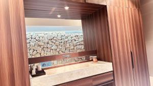 a bathroom with a mirror and a stone wall at Ha Garden house in Nha Trang +23 photos