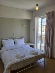 a bedroom with a bed with two towels on it at Kalamata Apartment Beach Front in Kalamata