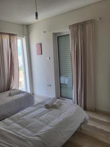 a bedroom with two beds and a large window at Kalamata Apartment Beach Front in Kalamata +4 photos