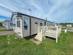 a small house with a porch and a fence at 6 Berth Caravan With Decking At Sunnydale Holiday Park Ref 35243Kg in Louth