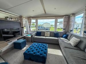 a living room with a couch and a flat screen tv at 6 Berth Caravan With Decking At Sunnydale Holiday Park Ref 35243Kg in Louth