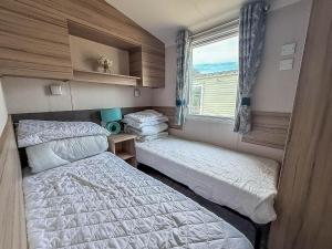 a small bedroom with two beds and a window at 6 Berth Caravan With Decking At Sunnydale Holiday Park Ref 35243Kg in Louth