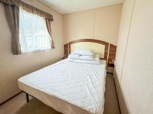 a bedroom with a large bed with white sheets and a window at 8 Berth Caravan With Decking At Sunnydale In Lincolnshire Ref 35087S in Louth +10 photos