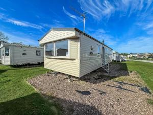 a tiny house sitting on top of a yard at Homely 8 Berth Caravan At Sunnydale In Lincolnshire Ref 35069S in Louth