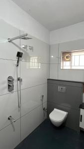 een witte badkamer met toilet en douche bij Vintage Coffee Premium Villa in Pinangode