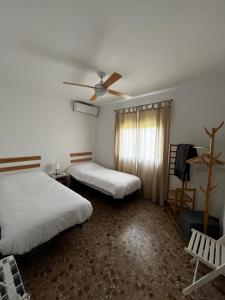 a room with two beds and a ceiling fan at La casa de mamá in Lorca +30 photos