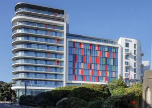 een groot kantoorgebouw met rode en blauwe ramen bij Hilton Bournemouth in Bournemouth