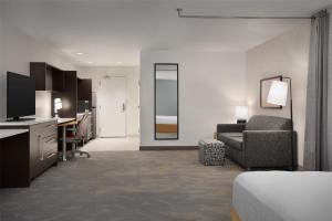 a hotel room with a couch and a chair and a desk at Home2 Suites by Hilton Sioux Falls Sanford Medical Center in Sioux Falls