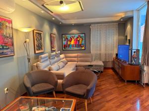 a living room with a couch and chairs and a tv at Blue Stella Luxury Apartment in Split