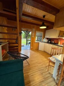 a kitchen and living room with a table and chairs at Maharówka - Domki z sauną i balią - Ostrowo - holiday home in Ostrowo