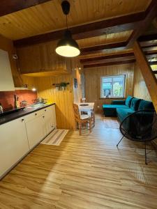a kitchen and living room with a blue couch at Maharówka - Domki z sauną i balią - Ostrowo - holiday home in Ostrowo +102 photos