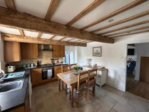 a kitchen with a wooden table and chairs in it at The Barn Cottage in Oakworth