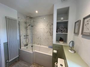 a bathroom with a shower and a bath tub at The Barn Cottage in Oakworth +13 photos