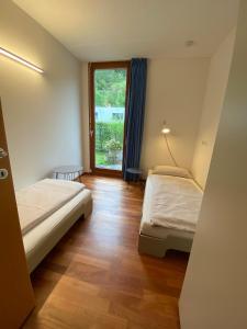 Una pequeña habitación con dos camas y una ventana. en Lebensfreude, en Dornbirn