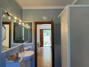 a blue bathroom with a sink and a mirror at La Serenella in Porto Ercole +18 photos