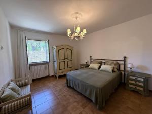 a bedroom with a bed and a chandelier at La Serenella in Porto Ercole