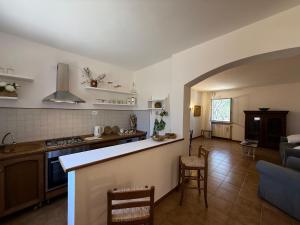 a kitchen with a counter and a living room at La Serenella in Porto Ercole