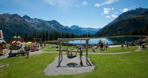 a group of people in a park with a swing at Alp Chalet Appartement in Kappl