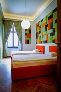 ein Schlafzimmer mit 2 Betten mit farbenfroher Kunst an den Wänden in der Unterkunft Arina Apartments 2 in Braşov