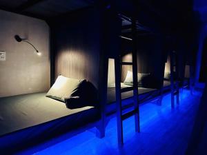 two bunk beds in a room with blue lights at Tzone's Hostel - Quiet Place in Ho Chi Minh City