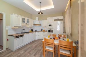 a kitchen with white cabinets and a table and chairs at Casa dei nonni in Argostoli