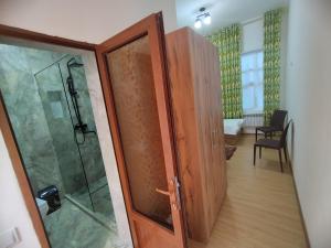 a bathroom with a shower and a glass door at Sahro Hotel in Bukhara