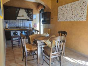 a kitchen with a wooden table and chairs in a room at La tua Casa a due passi dal Mare in Avola