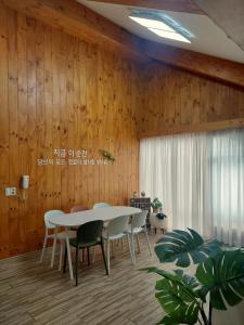 a dining room with a white table and chairs at 지금이순간 in Busan