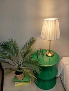 a lamp on a green table next to a plant at 지금이순간 in Busan