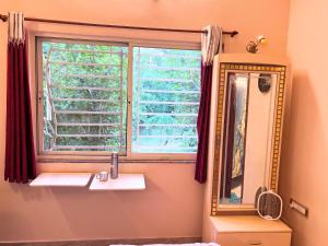 a bathroom with a mirror and a sink and a window at Green Serene Estate & home-stay in Puttaparthi +27 photos