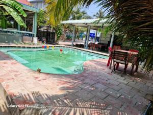 a swimming pool with a table and a chair next to it at Mekong way homestay in Cai Lậy +27 photos