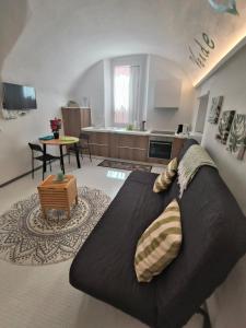 a living room with a black couch and a kitchen at Appartamento Ca' Sistina Green a Morcote in Morcote