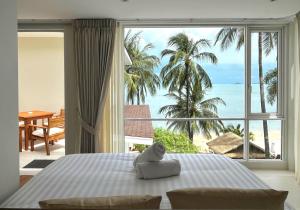 a bedroom with a bed with a view of the ocean at Baan Bophut Beach Hotel Samui - SHA Extra Plus in Bophut