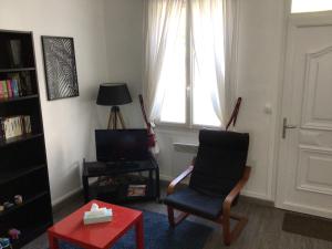 a living room with a chair and a television at Sara's Home 24 in Rouen