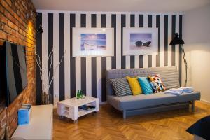 un soggiorno con divano e parete a righe di PuckApartments a Puck