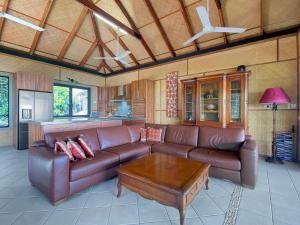 a living room with a brown leather couch and a table at Absolute Beachfront and Pool House in Horseshoe Bay