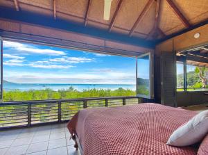 a bedroom with a bed and a view of the ocean at Absolute Beachfront and Pool House in Horseshoe Bay