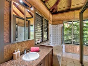 a bathroom with a sink and a tub and a mirror at Absolute Beachfront and Pool House in Horseshoe Bay