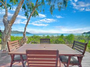 a wooden table and chairs with a view of the ocean at Absolute Beachfront and Pool House in Horseshoe Bay