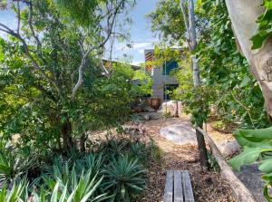 a garden with a wooden bench in front of a building at Absolute Beachfront and Pool House in Horseshoe Bay
