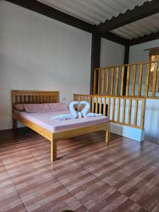 a bedroom with a bed and a wooden floor at Immanuel inn in Siquijor