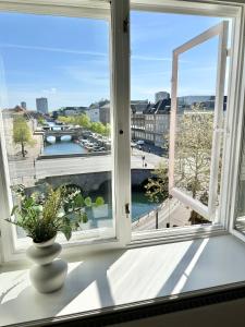 a vase on a window sill with a view of a city at Deluxe 4 Bedrooms 180 m2 Canal View Prime Location in Copenhagen