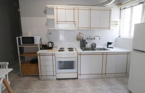 una cocina con armarios blancos y un horno de fogón blanco en Casa alle terme, en Loutra Edipsou 5 fotos más