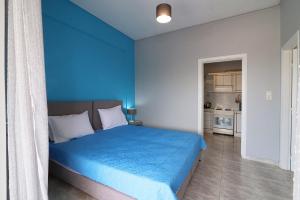 1 dormitorio azul con 1 cama y cocina en Casa alle terme, en Loutra Edipsou