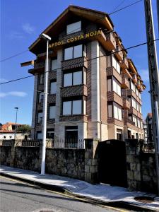 a building on the corner of a street at Apartamentos Costa Noja in Noja