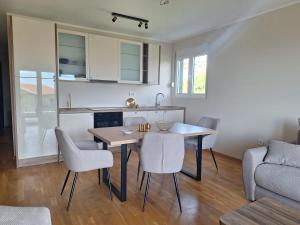 a kitchen and dining room with a table and chairs at Apartment Alma in Kravlja +2 photos