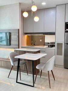 a kitchen with a white table and two chairs at Lush Lakeside - Citra Luxury Apartments in Jakarta