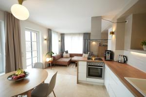 a kitchen and living room with a table and a couch at Appartement Am-Wildpfad in Bad Goisern