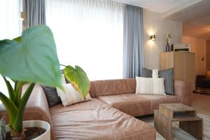 a living room with a brown couch in front of a window at Appartement Am-Wildpfad in Bad Goisern